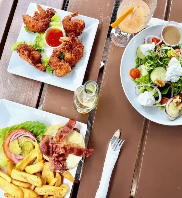 Coconut shrimp with sweet chili sauce, a salad and a sandwich with fries