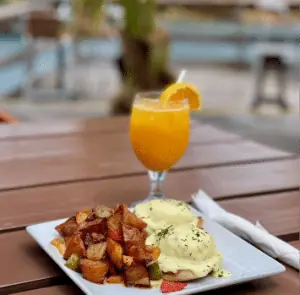 Eggs Benedict with home fries and fresh orange juice