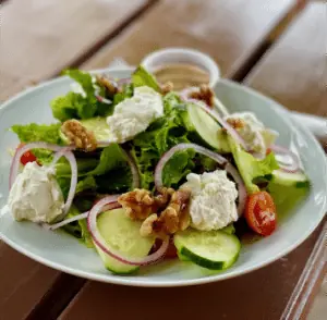 Goat cheese salad with walnuts, cucumber and red onion