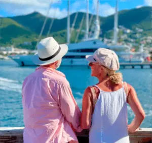 A couple in sun hats watching the boats from the waterfront