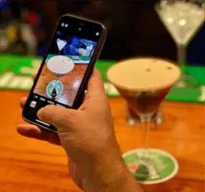 A guest photographing an espresso martini on the bar