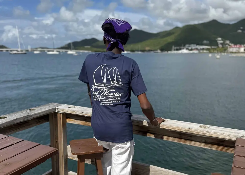A guest in an SMYC t-shirt looking out over the lagoon from the deck