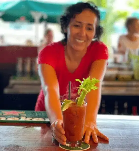 A bartender serving the Bloody Mary, garnished with celery